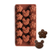 Silicone mold with bear and flower shapes and two chocolate candies on a white background