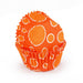 Orange cupcake liner with white polka dots on a white background