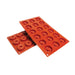Red silicone savarin baking mold with mini ring-shaped cavities for creating individual cakes, mousse desserts, chocolates, pastries, and professional plated dessert presentations.