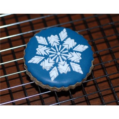 Decorated blue winter cookie with detailed snowflake stencil design
